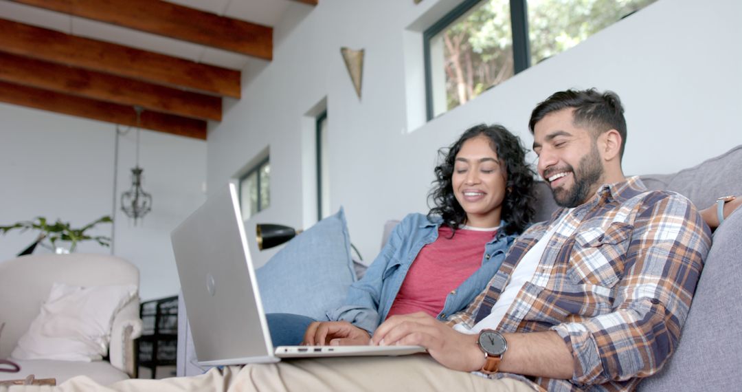 Happy Couple Using Laptop on Cozy Sofa at Home