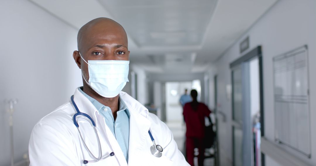 Confident African American Doctor Wearing Mask in Hospital Corridor - Free Images, Stock Photos and Pictures on Pikwizard.com