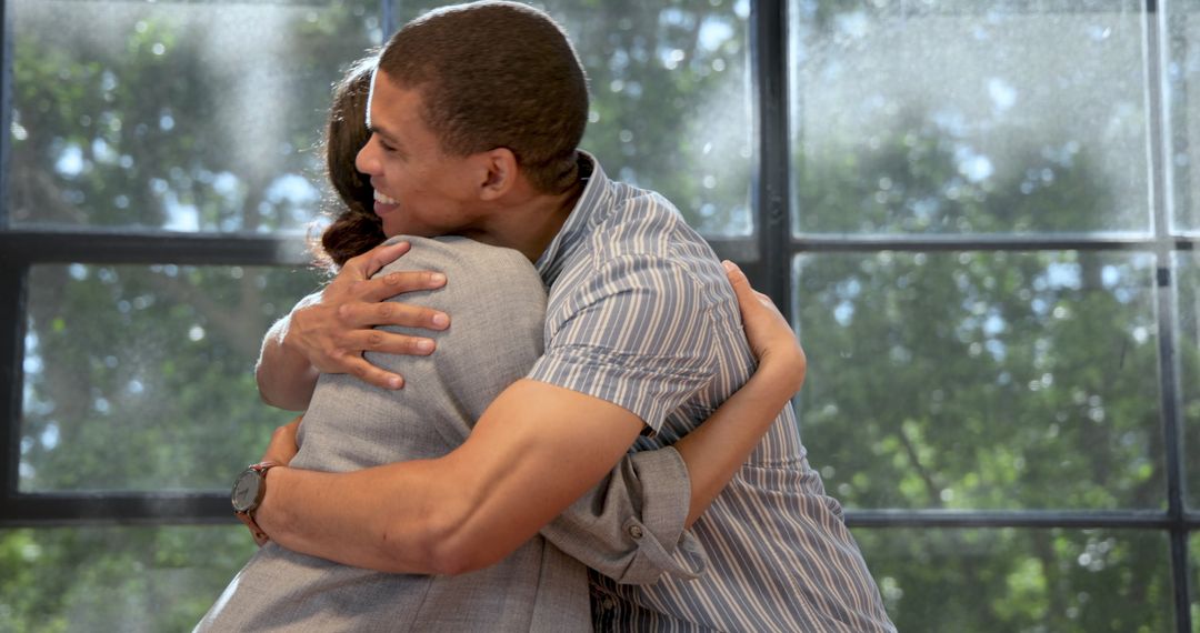 Joyful Businessman Hugging Colleague with Bright Smile
