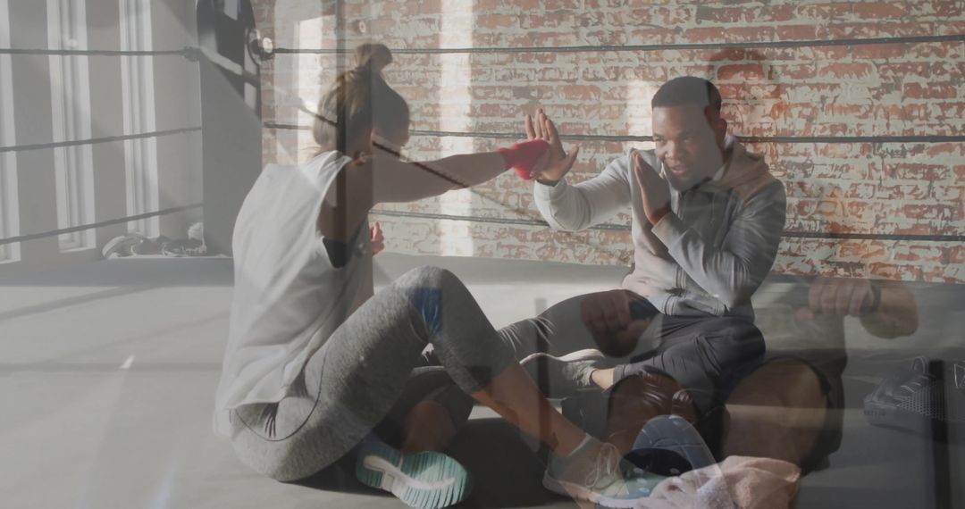 Trainee Practicing Boxing Jabs with Trainer in Loft Gym