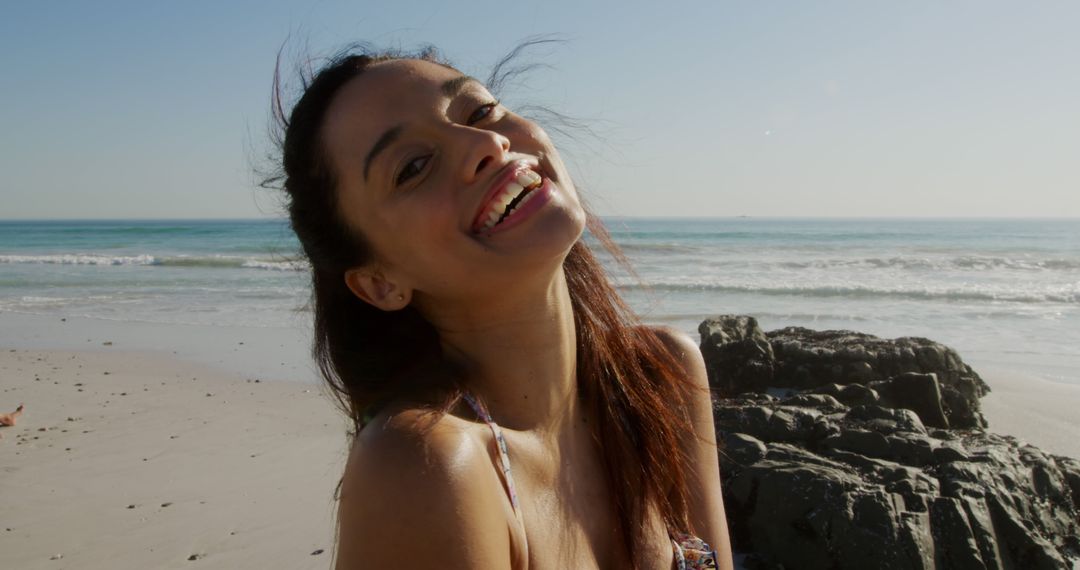 Portrait of happy biracial woman with long brown hair at sunny beach - Free Images, Stock Photos and Pictures on Pikwizard.com