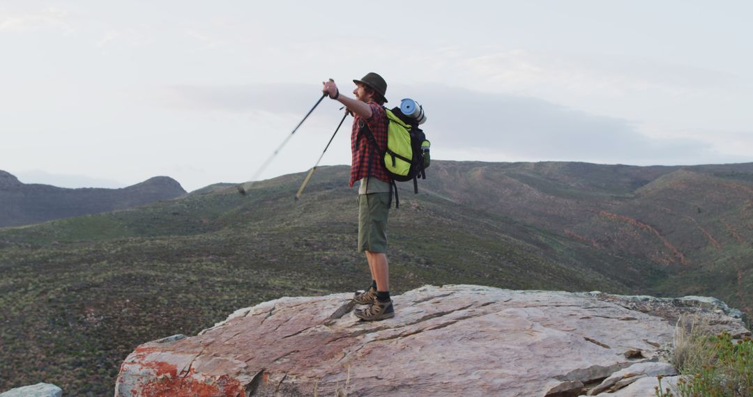 Adventurous Hiker Stretching Arms on Mountain Rock - Free Images, Stock Photos and Pictures on Pikwizard.com