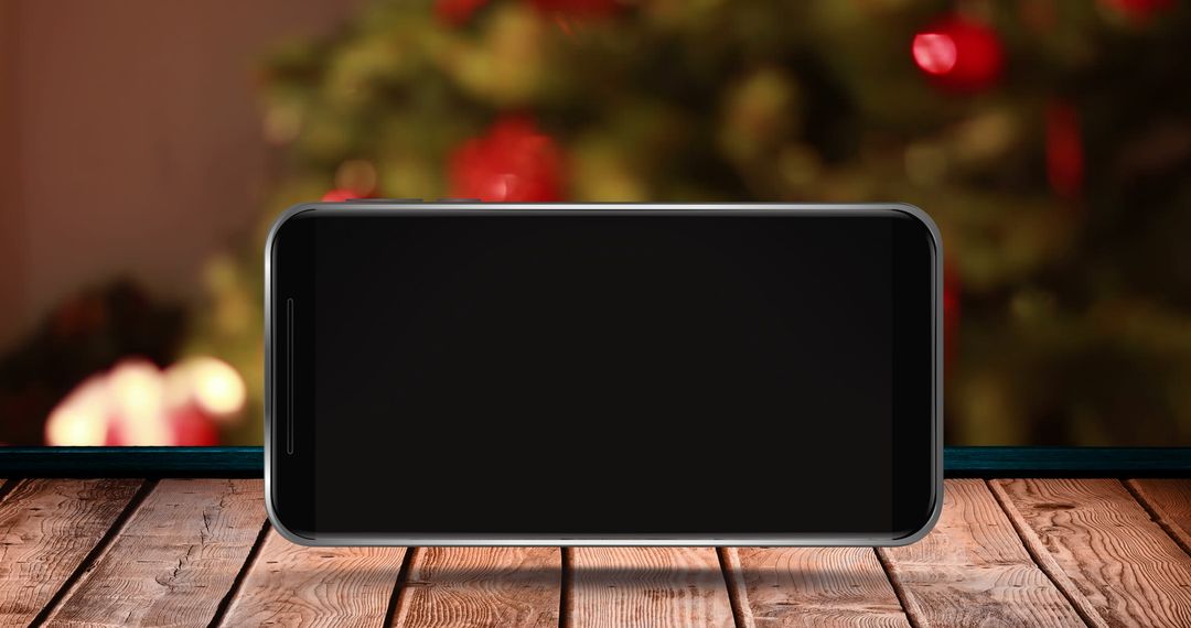 Blank Smartphone on Wooden Surface with Blurred Christmas Tree