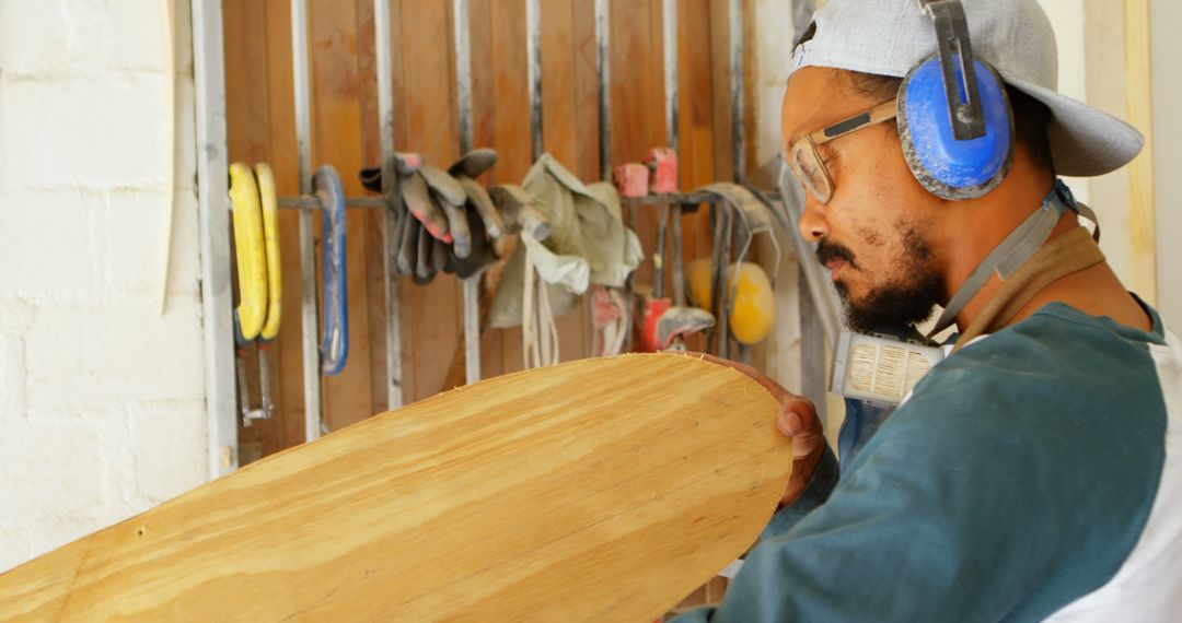 Focused Male Carpenter Shaping Surfboard in Workshop - Free Images, Stock Photos and Pictures on Pikwizard.com