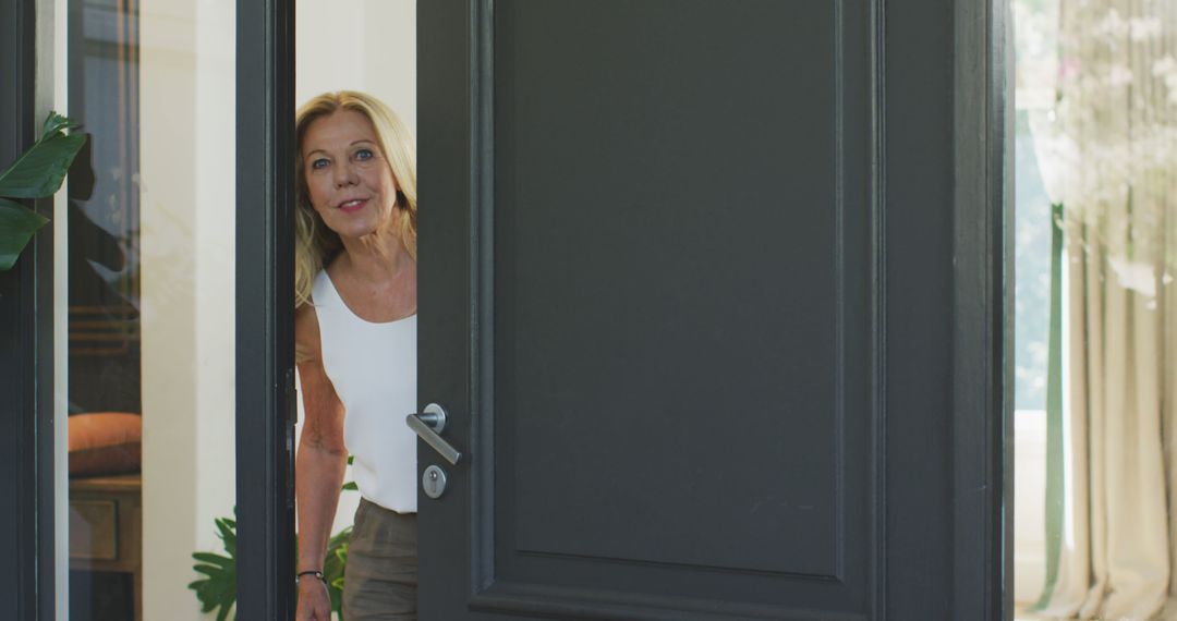 Smiling Middle-Aged Woman Opening Front Door to Greet Visitors - Free Images, Stock Photos and Pictures on Pikwizard.com