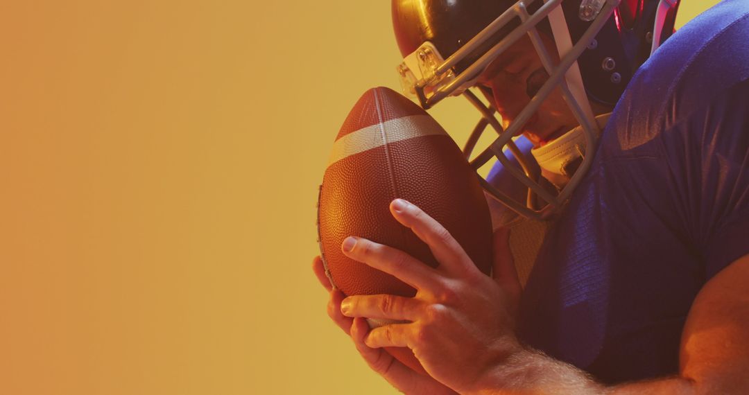 American Football Player Holding Ball Against Orange Gradient Background - Free Images, Stock Photos and Pictures on Pikwizard.com