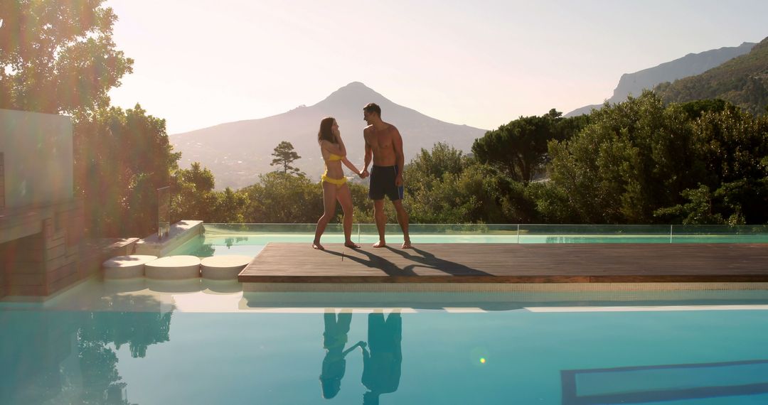 Romantic Couple Holding Hands by Infinity Pool at Sunset - Free Images, Stock Photos and Pictures on Pikwizard.com