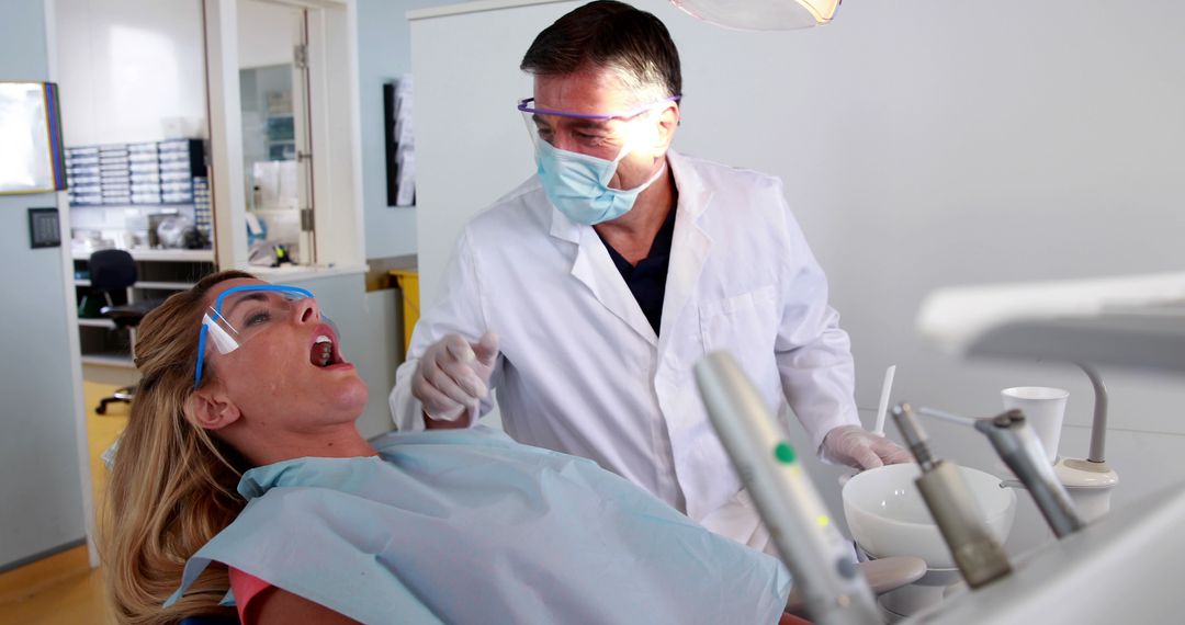 Dentist Treating Female Patient in Clinical Office - Free Images, Stock Photos and Pictures on Pikwizard.com