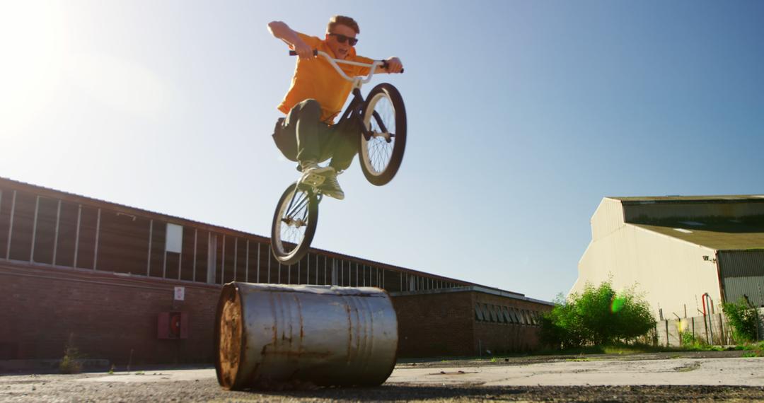 Young BMX Rider Jumping Over Barrel Outdoors - Free Images, Stock Photos and Pictures on Pikwizard.com