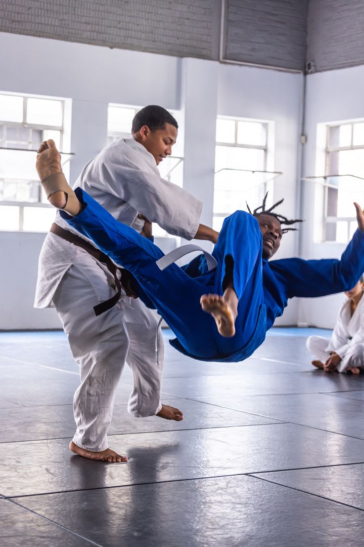 Martial Arts Students Practicing Throw Technique in Studio