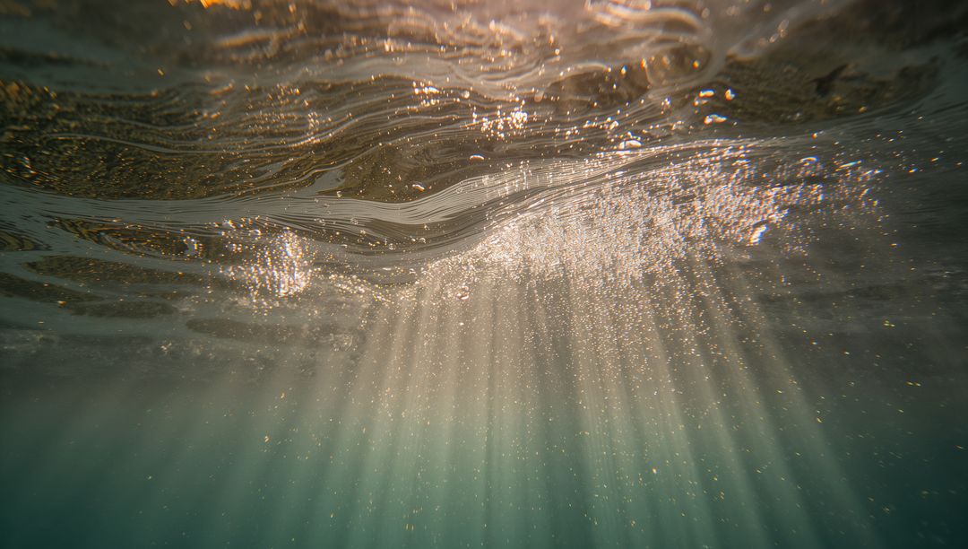 Sunbeams Submerging Through Tranquil Ocean Water with Suspended Particles