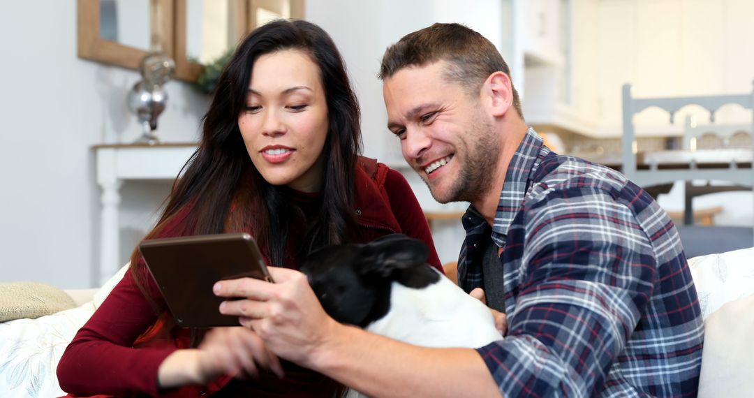 Couple Relaxing on Couch with Tablet and Dog