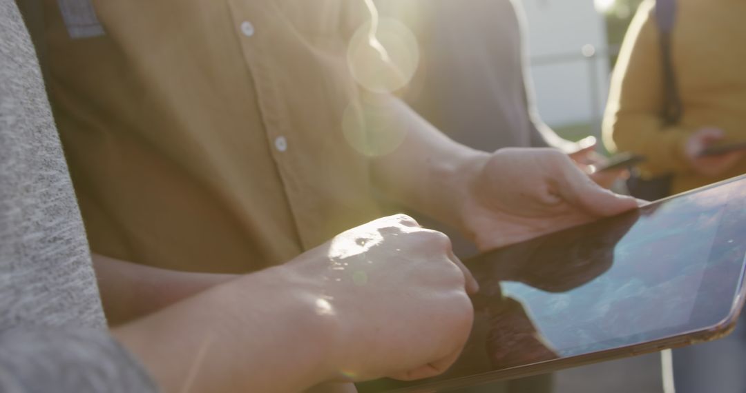 People using a tablet outdoors with sunlight glare - Free Images, Stock Photos and Pictures on Pikwizard.com