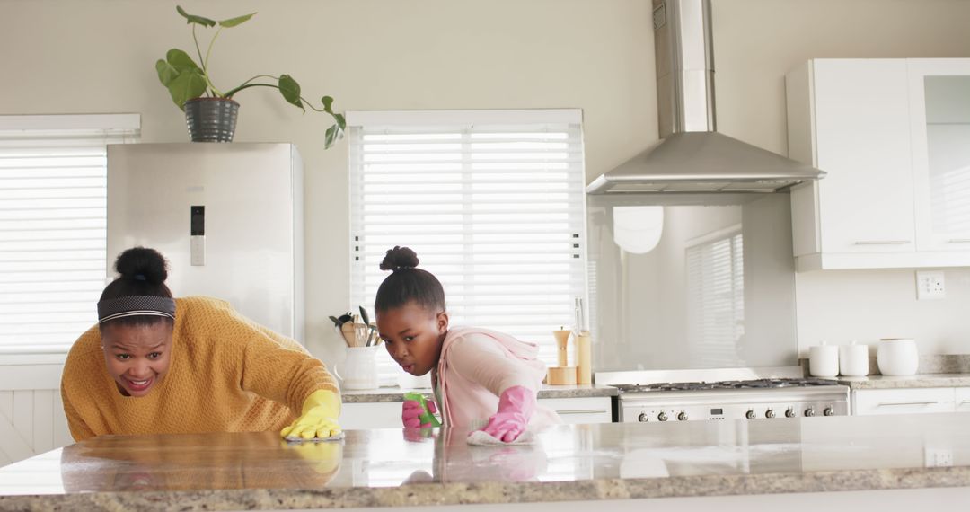 Happy Biracial Mother and Daughter Cleaning Together in Modern Kitchen - Free Images, Stock Photos and Pictures on Pikwizard.com