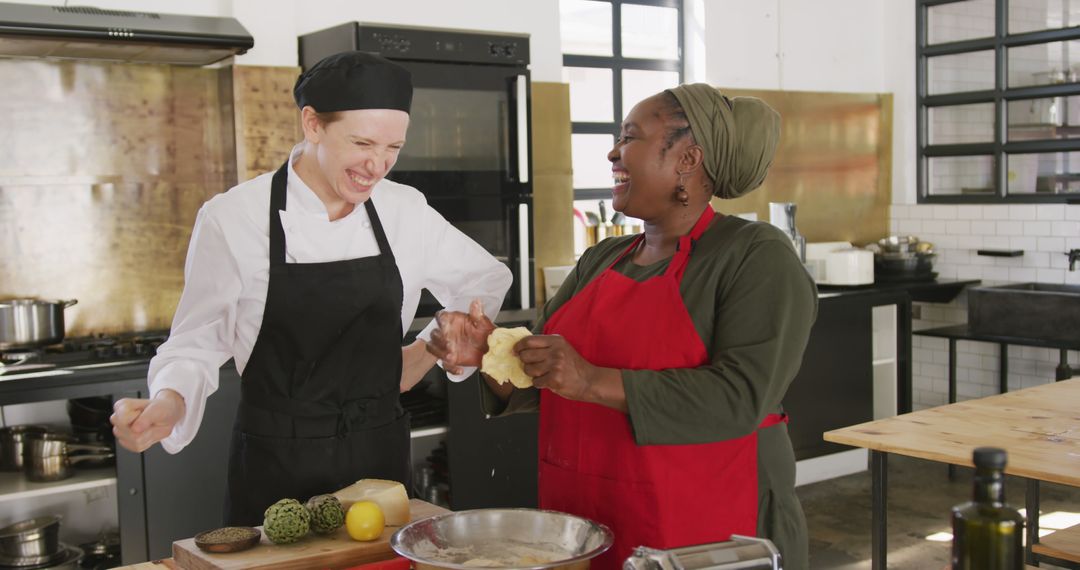 Two Female Chefs Enjoy Cooking Together in Commercial Kitchen - Free Images, Stock Photos and Pictures on Pikwizard.com