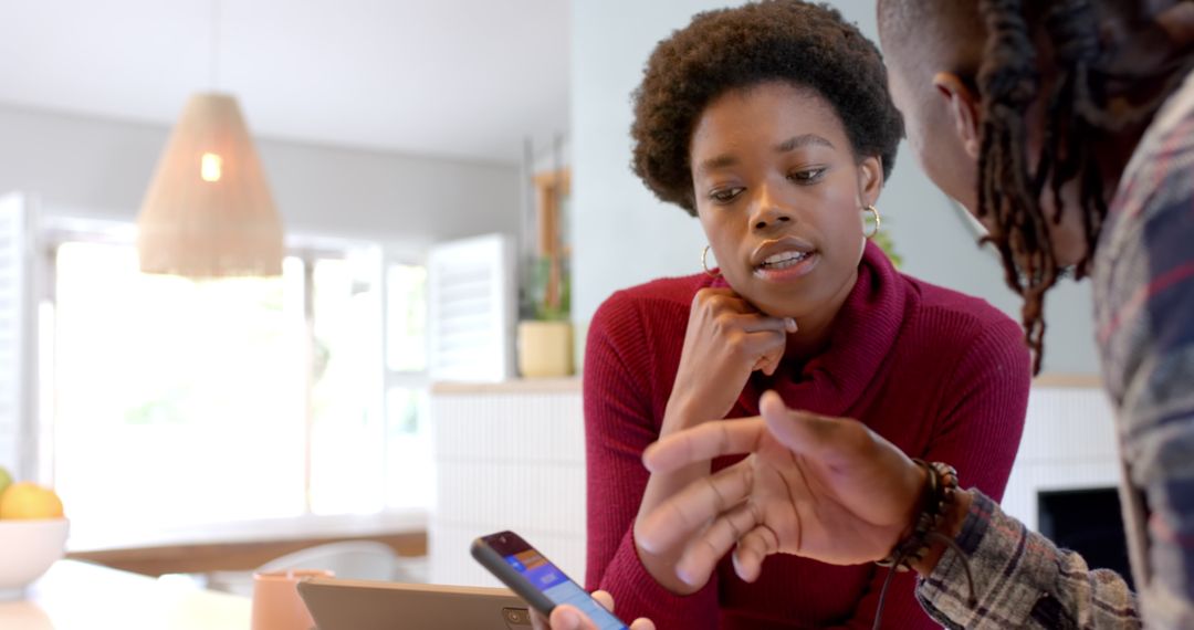 Two Friends Collaborating on Project Using Technology in Modern Kitchen
