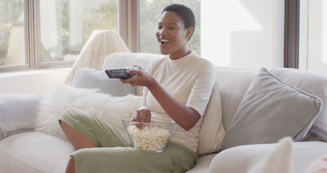 Woman Relaxing on Couch Watching TV and Eating Popcorn - Free Images, Stock Photos and Pictures on Pikwizard.com