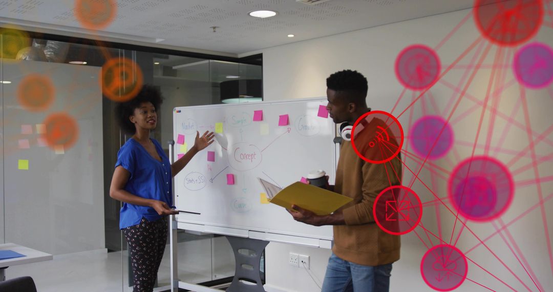 Colleagues brainstorming at whiteboard with sticky notes collaborating in modern glass office