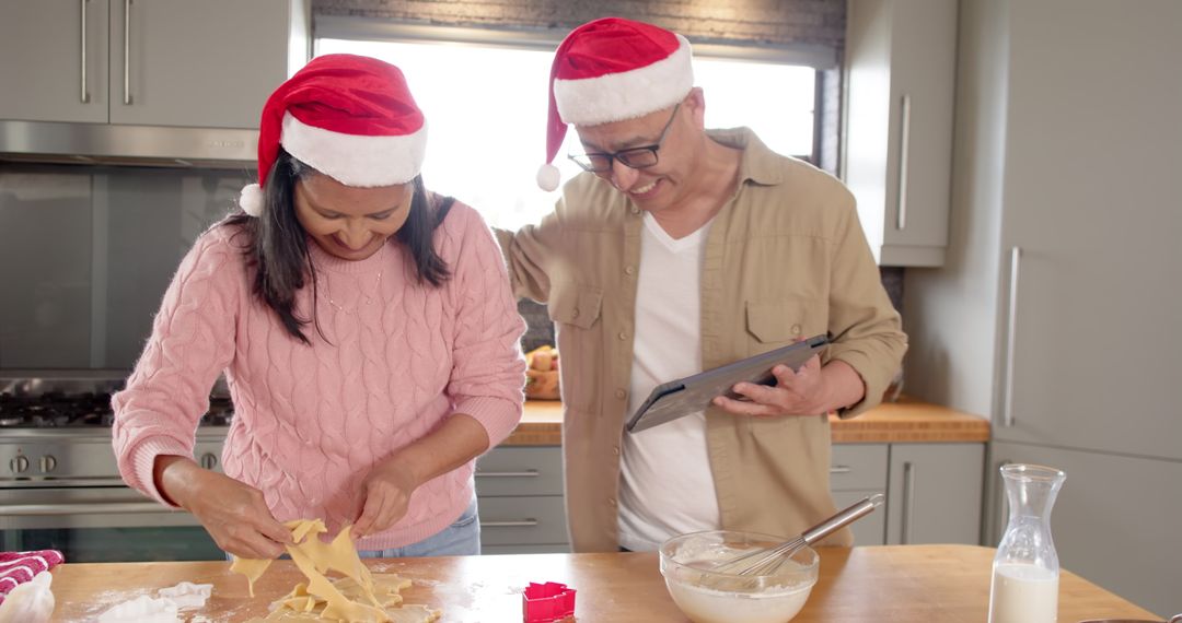 Diverse Couple Making Holiday Cookies Using Tablet