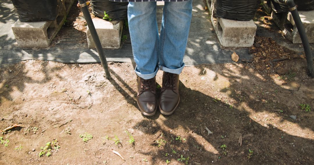 Gardener in Rolled-Up Jeans Standing at Plant Nursery