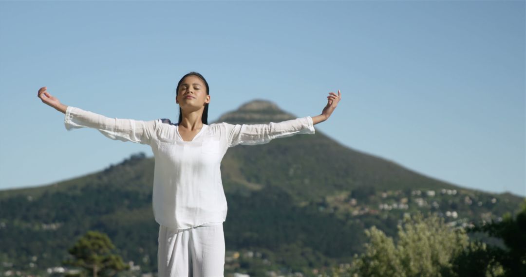 Woman Relaxing in Mountain Scenery with Arms Outstretched - Free Images, Stock Photos and Pictures on Pikwizard.com