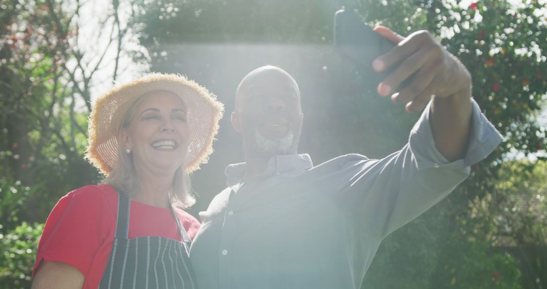 Happy Senior Couple Taking Selfie Outdoors in Sunny Garden - Free Images, Stock Photos and Pictures on Pikwizard.com