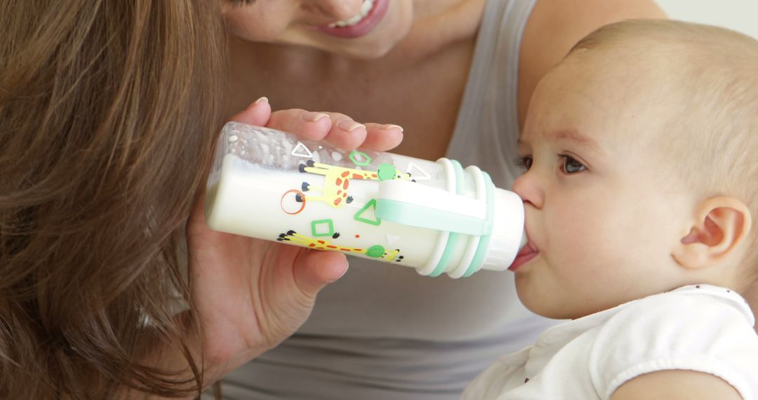 Close-up of Baby Drinking from Bottle with Mother Helping - Free Images, Stock Photos and Pictures on Pikwizard.com