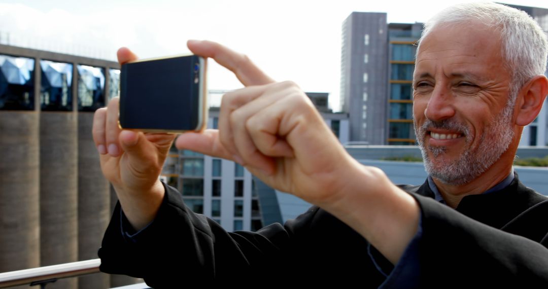 Elderly Man Taking Photo on Rooftop, Urban Background - Free Images, Stock Photos and Pictures on Pikwizard.com