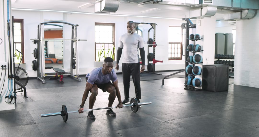 Personal Trainer Guiding Athlete in Weightlifting Techniques