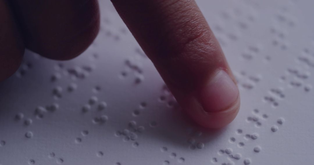 Finger Tracing Braille Dots on Paper Closeup Tactile Reading Accessibility Concept