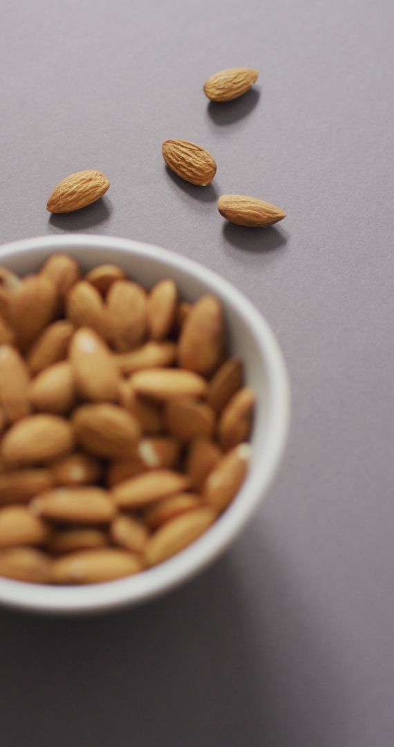 Vertical Image of Fresh Almonds in Bowl on Lilac Background - Free Images, Stock Photos and Pictures on Pikwizard.com