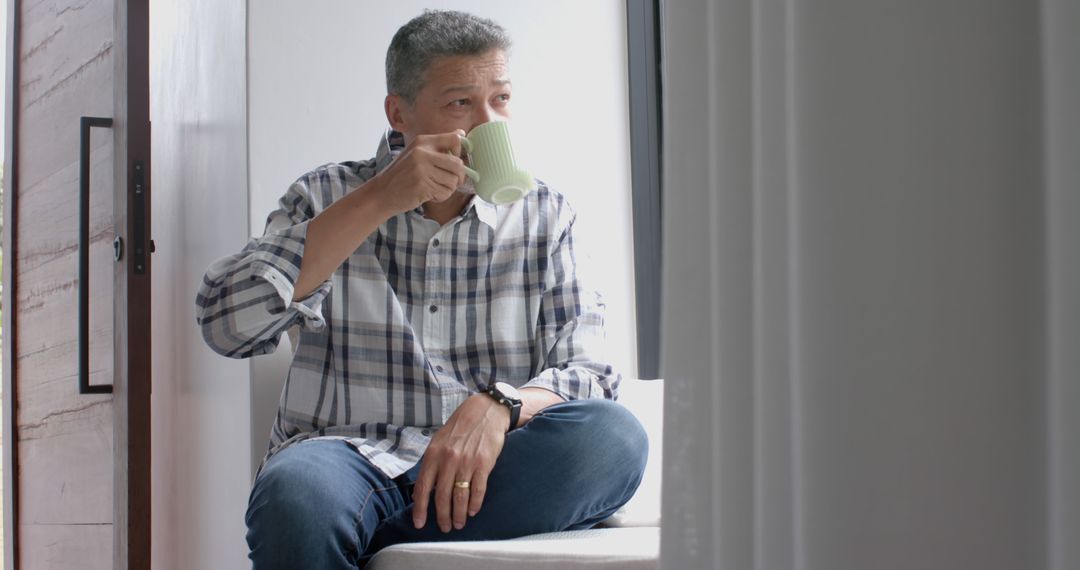 Mature Man Sipping Coffee While Relaxing at Home - Free Images, Stock Photos and Pictures on Pikwizard.com