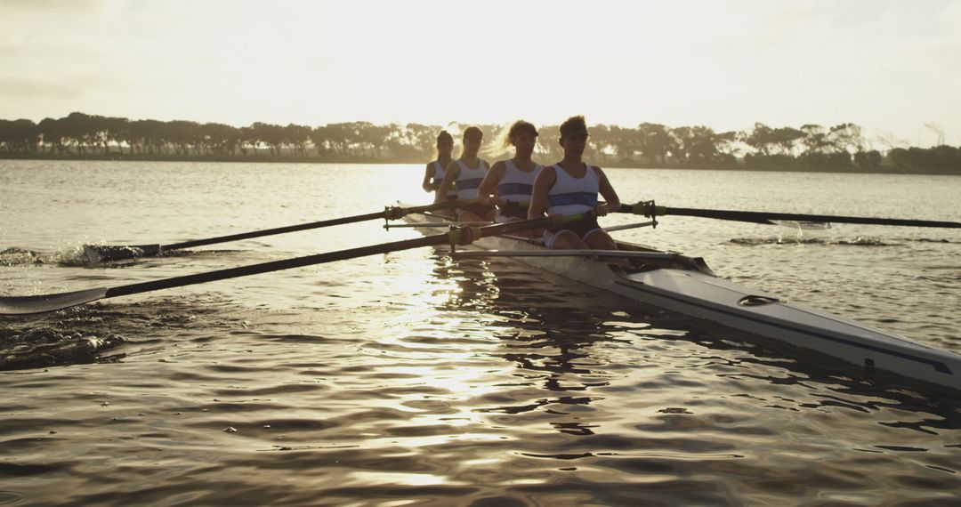 Four Rowers Team Rowing Boat on Lake at Sunset - Free Images, Stock Photos and Pictures on Pikwizard.com
