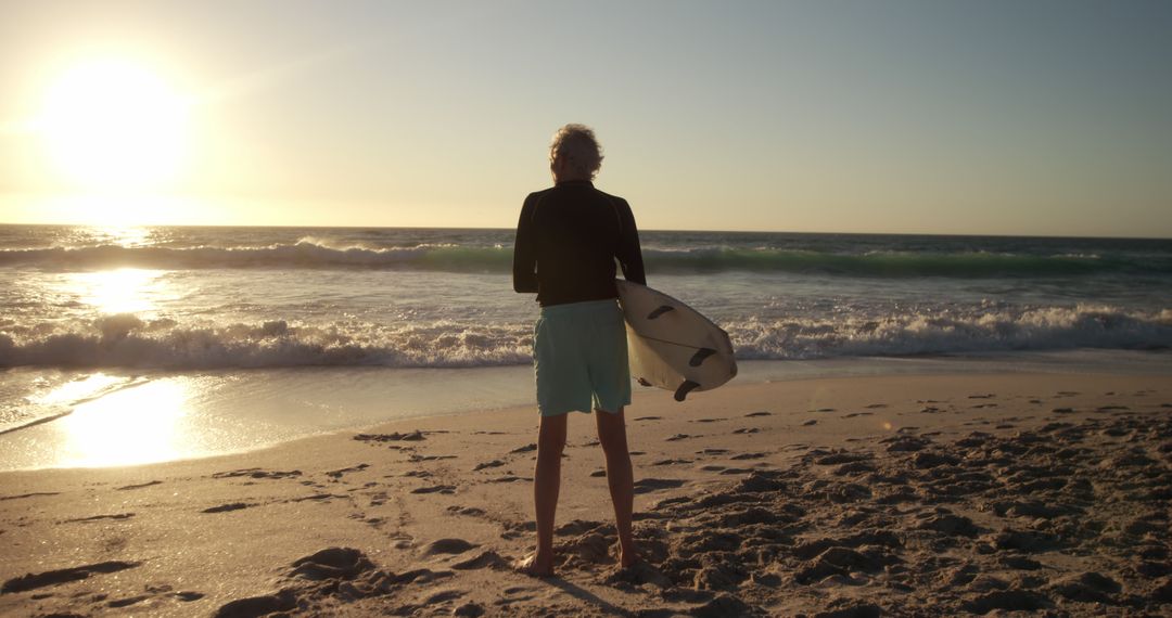 Surfer Watching Sunset on Beach with Surfboard - Free Images, Stock Photos and Pictures on Pikwizard.com