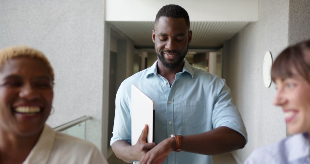 Smiling Businessman Checking Watch with Colleagues in Office Hallway