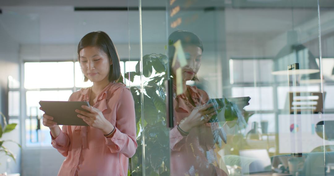 Office Professional Using Tablet with Reflection in Glass