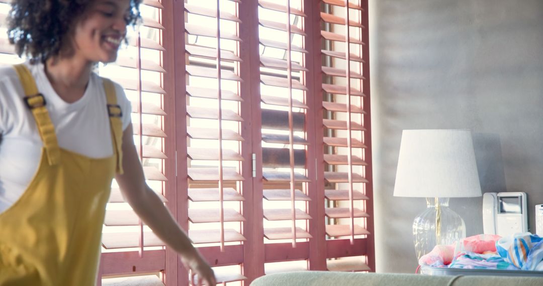 Woman Relaxes on Couch Using Smartphone Near Sunny Window
