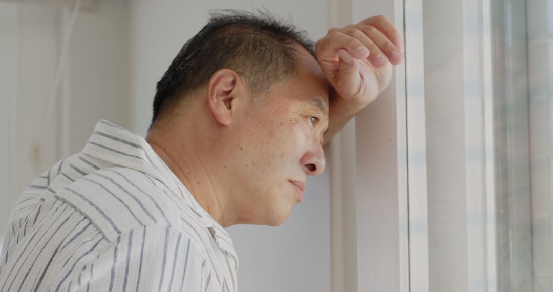 Thoughtful Elderly Man Gazing Through Window in Serene Homescape