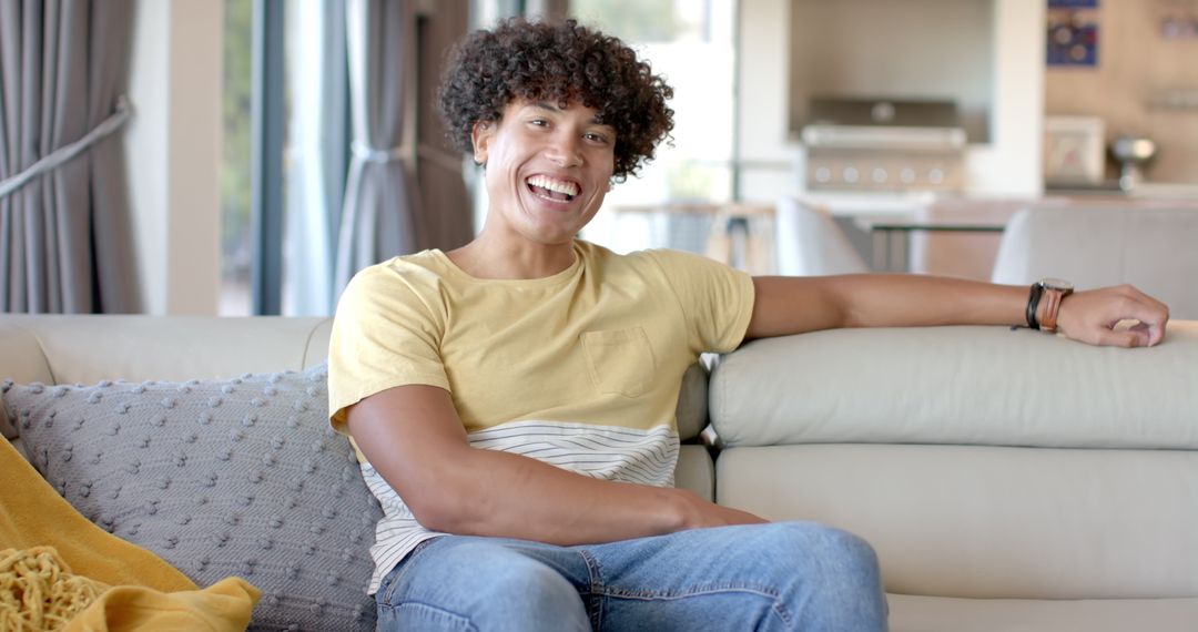 Smiling Man Relaxing on Couch in Modern Living Room