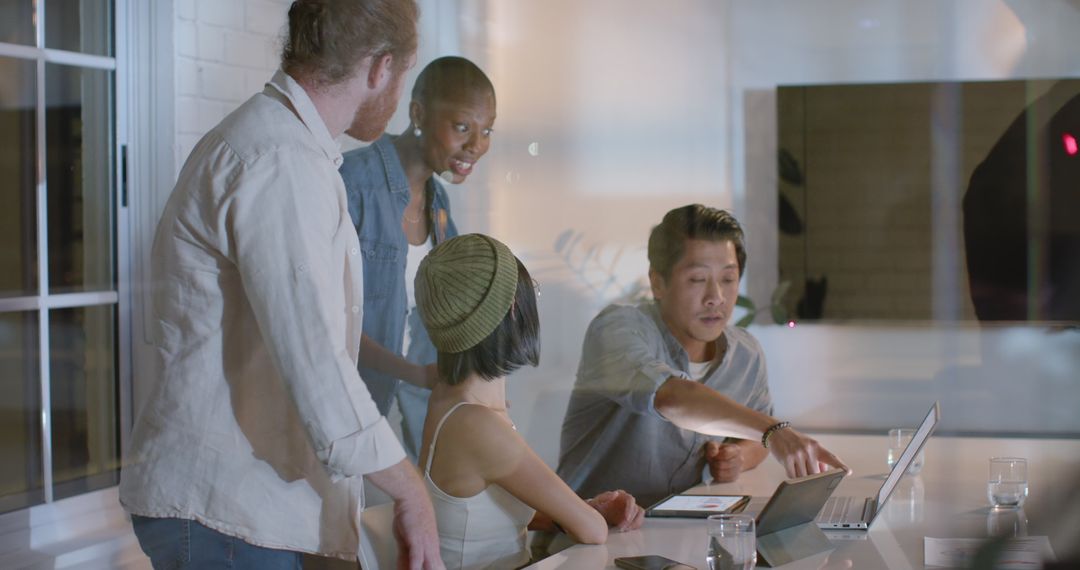 Diverse Team Collaborating with Technology in Modern Office at Night