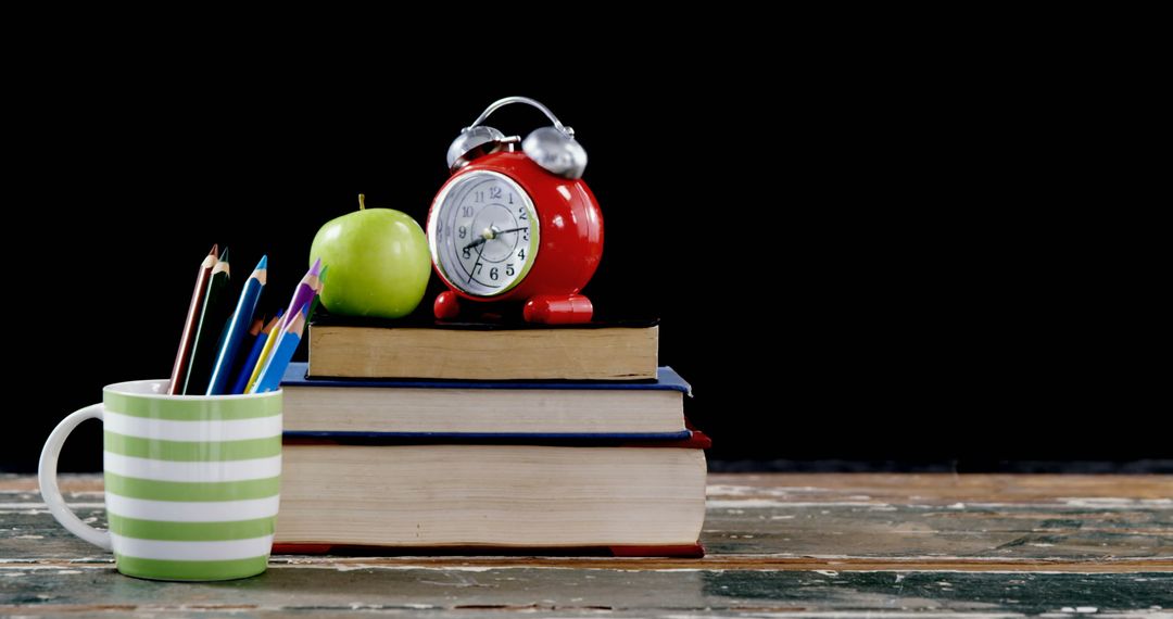Vintage Alarm Clock and Books with Apple on Desk