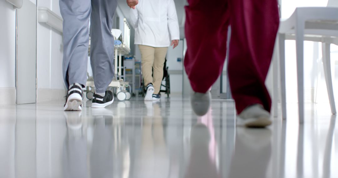 Health Professionals Walking Hospital Hallway with Reflection - Free Images, Stock Photos and Pictures on Pikwizard.com