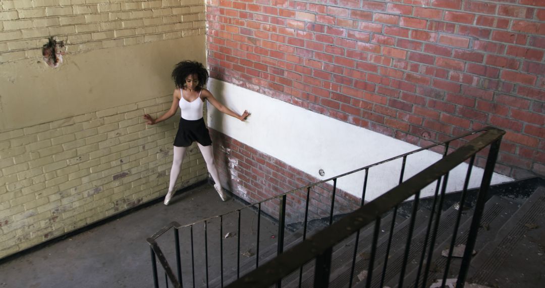 Ballerina Practicing Dance Moves in Rustic Stairwell - Free Images, Stock Photos and Pictures on Pikwizard.com