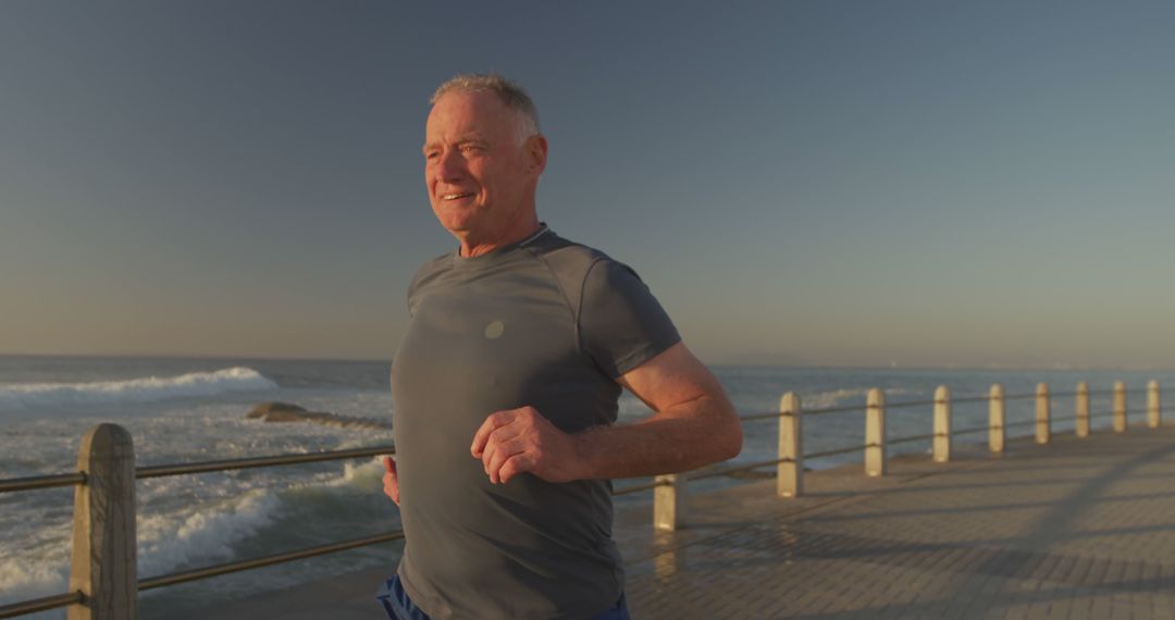 Senior Man Jogging Along Oceanfront Pier During Sunrise for Exercise - Free Images, Stock Photos and Pictures on Pikwizard.com