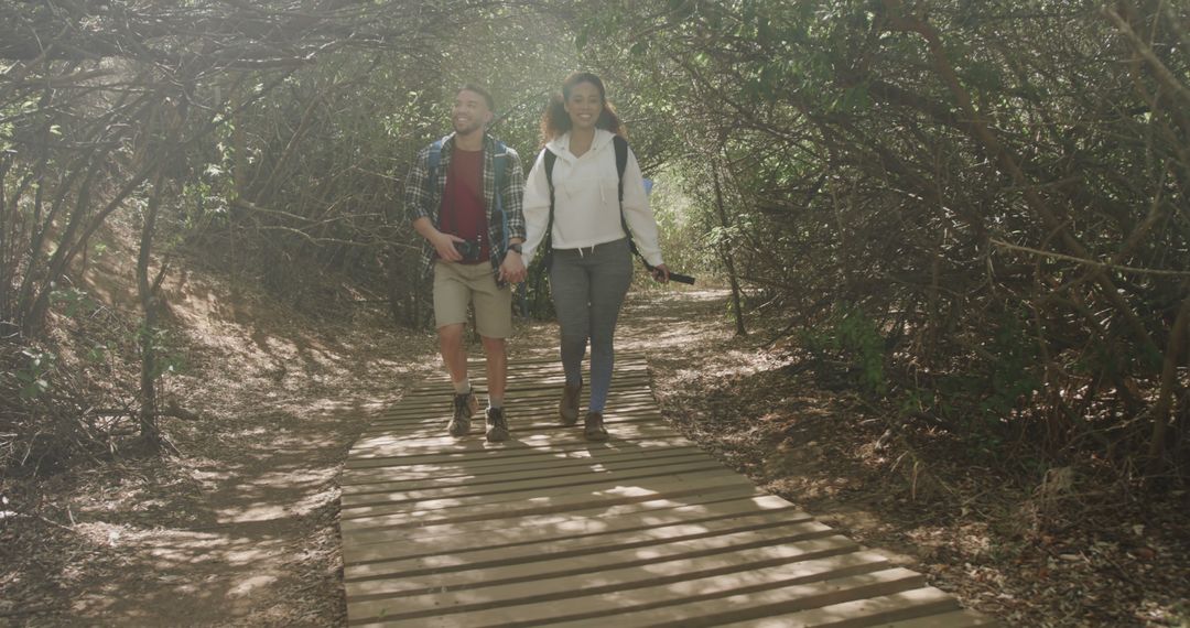 Happy Couple Walking on Wooden Path in Forest - Free Images, Stock Photos and Pictures on Pikwizard.com