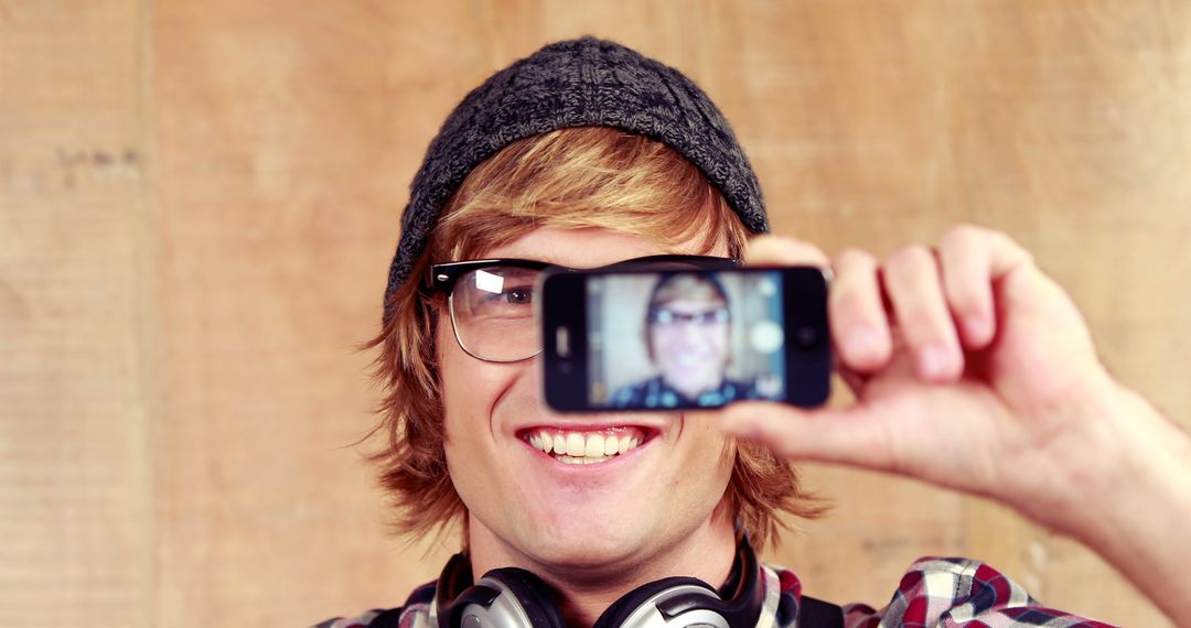 Man with headphones taking selfie smiling in casual outfit - Free Images, Stock Photos and Pictures on Pikwizard.com