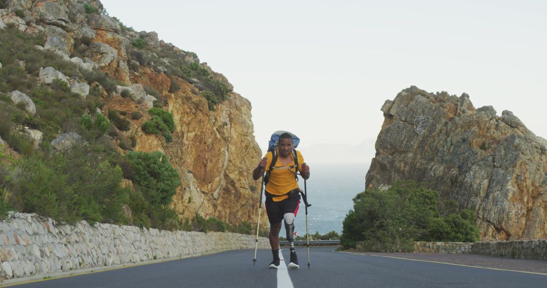 Determined Hiker with Prosthetic Leg Trekking on Mountain Road - Free Images, Stock Photos and Pictures on Pikwizard.com