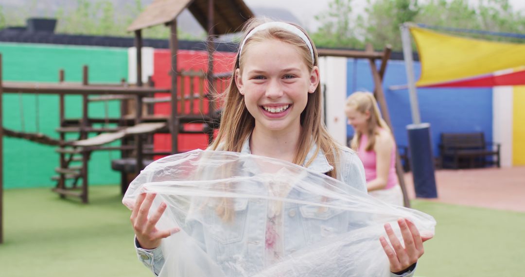 Portrait of happy caucasian schoolchildren cleaning with bags at school playground - Free Images, Stock Photos and Pictures on Pikwizard.com