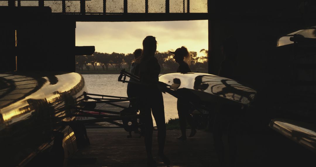 Team of Rowers Preparing Boat at Sunset by Riverside - Free Images, Stock Photos and Pictures on Pikwizard.com