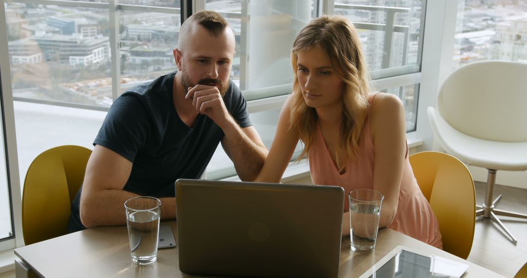 Man and Woman Working Together on Laptop in Modern Office - Free Images, Stock Photos and Pictures on Pikwizard.com